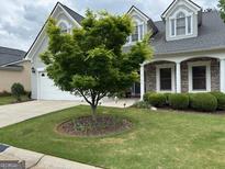 Charming home features a manicured lawn, stone accents, and a welcoming front entrance at 211 Collierstown Way, Peachtree City, GA 30269