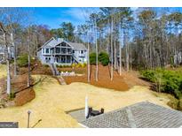 Charming gray home with a screened-in porch and outdoor seating on a sunny, landscaped lot at 2304 Larchmont Ct, Villa Rica, GA 30180