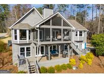 Beautiful gray home featuring a screened-in porch with modern outdoor furniture, and a tiered deck for entertaining at 2304 Larchmont Ct, Villa Rica, GA 30180