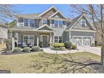 Charming two-story home boasts stone accents, a manicured lawn, and inviting front porch at 22 Marvin Gardens, Sharpsburg, GA 30277