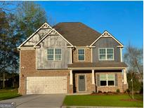 Charming two-story home features a brick and siding exterior, attached garage, and well-maintained lawn at 101 Elkins Blvd # 53, Locust Grove, GA 30248