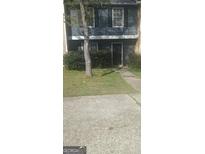 Two-story townhome featuring a gray exterior, black shutters, and a well-maintained front yard at 8547 Jamestown Way, Jonesboro, GA 30238