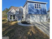 Stunning two-story home with a light gray brick, light blue panels, and large windows at 3724 River Ridge Ct, Decatur, GA 30034