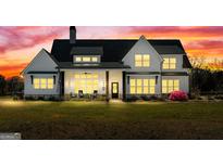 Stunning two-story home featuring a covered porch, black roof, dormer windows, and a manicured lawn at 105 Coogler Way, Brooks, GA 30205