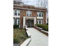 Charming red brick apartment building with white trim, a walkway, and well-maintained landscaping at 242 12Th St Ne 1 1A, Atlanta, GA 30309