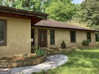 Charming home featuring a warm brown front door, stone accents, and inviting landscaping at 1288 Lakewood Ne Dr, Conyers, GA 30013