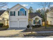Charming two-story home featuring a two-car garage, green shutters and well maintained landscaping at 2722 S Hills S, Riverdale, GA 30296