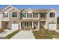 Charming townhouse featuring a brick and siding exterior, single-car garages, and well-maintained landscaping at 1946 Old Dogwood # 31, Jonesboro, GA 30238