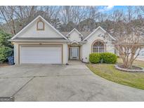 Charming stucco home featuring a two-car garage and well-manicured landscaping in a lovely community at 301 Newfield Way, Peachtree City, GA 30269
