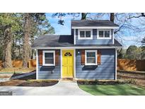 Charming blue home featuring a striking yellow front door and neat landscaping at 4657 Elam Church Rd, Forest Park, GA 30297