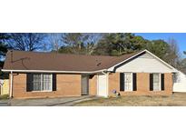 Charming one story brick home featuring black shutters, a well-maintained roof, and an inviting entrance at 634 S Jeff Davis Dr, Fayetteville, GA 30215