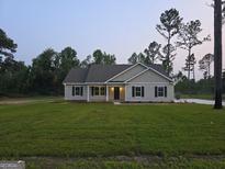 Charming single-story home featuring black shutters, a well-kept lawn, and a welcoming entrance at 22638 Salem Church Rd, Metter, GA 30349