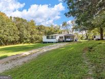 Charming single-story home with a spacious front yard and a convenient carport at 1202 Coan Dr, Locust Grove, GA 30248