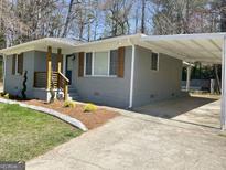 Charming gray brick home with a carport and landscaped front yard offering great curb appeal at 103 Greenwood Dr, Stockbridge, GA 30281