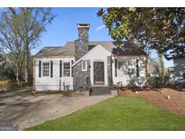 Charming home featuring a stone chimney, black shutters, and a well-manicured lawn at 2377 Beecher Sw Rd, Atlanta, GA 30311