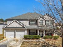 Charming two-story brick home with a two-car garage and well-maintained landscaping at 5864 Sunflower Ct, Ellenwood, GA 30294