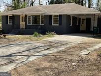 Charming single-story home with a covered porch, classic architectural details, and a spacious front yard at 1271 Sanders Dr, Lake City, GA 30260