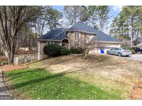 Charming two-story house showcasing stone and stucco accents, an arched doorway, and a well-manicured lawn at 1593 Brynwood Nw Ct, Acworth, GA 30101