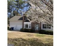 Charming two-story home with brick facade and blossoming tree in the front yard at 645 Legend Sw Ct, Atlanta, GA 30331