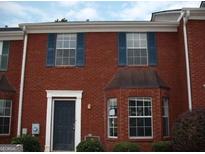 Charming brick townhome with blue shutters and a well-maintained front yard at 5567 Windfall Ln, Lithonia, GA 30058