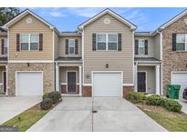 Charming townhouse with tan siding, brick accents, and well-maintained landscaping at 1310 Rogers Trce, Lithonia, GA 30058