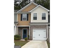 Charming two-story townhome featuring a brick facade, blue door, and attached one-car garage at 8642 Lakeview Commons # 36, Jonesboro, GA 30238