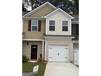 Attractive townhome exterior with a brick base, garage, neutral siding, and complementing landscaping at 8660 Lakeview Commons # 39, Jonesboro, GA 30238