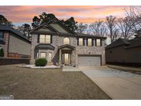 Charming two-story brick home with a manicured lawn and two car garage at 605 Camano Way, Mcdonough, GA 30253