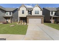 Two-story home featuring a brick and siding facade, two car garage and well manicured front lawn at 2458 Walker Dr, Hampton, GA 30228