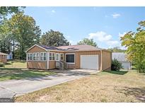 Charming single-story home featuring a sunroom, attached garage, and a well-maintained front yard at 2049 Nancy Se Cir, Smyrna, GA 30080