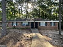 Charming brick multifamily home featuring a sidewalk leading to the front doors and green shutters, surrounded by trees at 6540 Lower Dixie Lake Rd, Union City, GA 30291