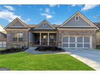 Charming one-story home with well-manicured lawn, brick accents, attached garage, and welcoming front porch at 1317 Elmswood Glen Way, Lawrenceville, GA 30045