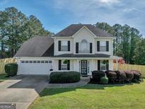 Charming two-story traditional home featuring a well-manicured lawn and a welcoming front porch at 720 Strawflower Ln, Locust Grove, GA 30248
