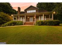 Charming two-story home with a welcoming front porch and manicured lawn at 135 Horseshoe Cir, Fayetteville, GA 30215