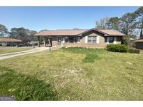 Charming single story brick home with carport and front yard featuring an easy to maintain lawn at 2574 Rosedale Dr, Morrow, GA 30260