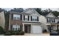Charming two-story home featuring a combination of brick and siding exterior, a well-maintained lawn, and a one car garage at 9487 Lakeview Rd, Union City, GA 30291