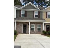 Charming townhome with brick facade, covered entryway, and well-maintained landscaping at 8654 Lakeview Commons # 38, Jonesboro, GA 30238