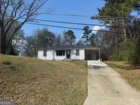 Charming one-story home with a white exterior and a long driveway at 6006 Blackhawk Se Trl, Mableton, GA 30126