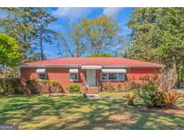 Charming brick ranch-style home featuring a red metal roof and a well-maintained front yard at 111 Highway 138 E, Stockbridge, GA 30281