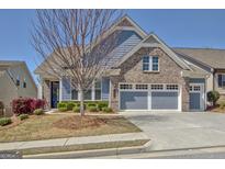 Charming two-story home with a two-car garage, blue siding, brick accents, and landscaped front yard at 108 Mulberry Ct, Peachtree City, GA 30269