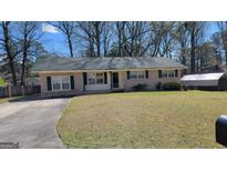 Charming brick ranch home with a well-maintained front yard and a long concrete driveway at 617 Virginia Cir, Forest Park, GA 30297