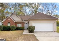 Charming single-story home with brick and vinyl siding, complemented by a well-maintained front yard and an attached garage at 116 Evenview Dr., Jonesboro, GA 30236