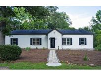 Charming white brick home featuring black shutters and a welcoming walkway to the front door at 281 New Hope Dr, Mcdonough, GA 30252