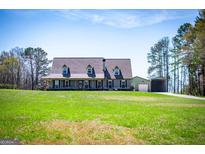 Charming home featuring a large front yard, covered porch, and a detached garage at 640 Lovell Rd, Temple, GA 30179