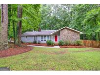 Charming ranch style home featuring stone accents and a vibrant red front door, nestled on a well-maintained lot at 346 Buckingham Sw Dr, Conyers, GA 30094