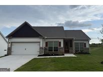 Charming single-Gathering home featuring a two-car garage, a well-manicured lawn, and neutral-colored siding at 661 Cantrell Drive, Dallas, GA 30157