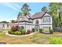 Stately two-story home boasts beautiful landscaping, lush lawn, and mature trees at 3144 Sherwood Oaks Ln, Decatur, GA 30034