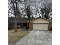 Traditional brick home featuring an attached two-car garage and a well-maintained front lawn at 2791 Biscayne Dr, Conyers, GA 30012