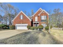 Charming two-story brick home featuring a two-car garage and well-manicured landscaping at 1824 Kristen Ct, Suwanee, GA 30024