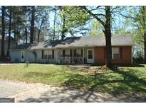 Charming one-story home with light blue siding, brick accents, red shutters, and a welcoming front porch at 121 Juniper Dr, Mcdonough, GA 30253